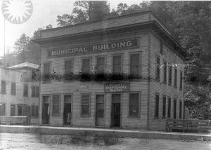 First National Bank and Municipal Building of Jenkins, Kentucky.   The photographer and date are both unknown.   But it is part of the Smithsonian Collection of Jenkins, Kentucky by the starburst watermark.